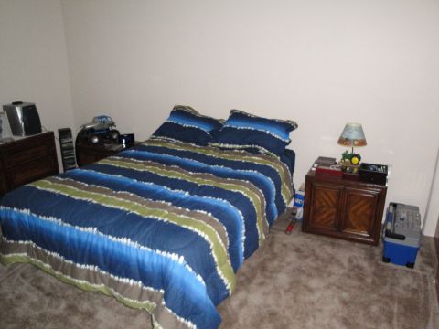 2000 Ford Crown Victoria - A bedroom scene with a bed, nightstand, dresser, and a toy truck on the nightstand.