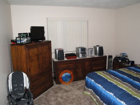 2000 Ford Crown Victoria - A toy monster truck sits on a dresser in a bedroom.