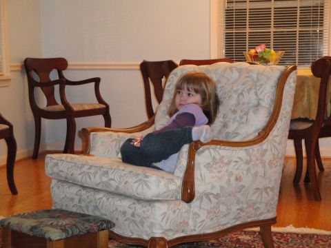 2000 Ford Crown Victoria - A young child relaxes in a comfortable armchair in a dining room setting.