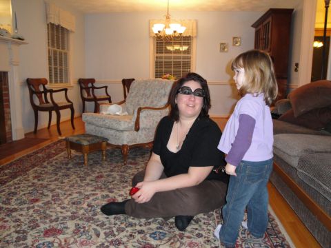 2000 Ford Crown Victoria - A woman wearing large sunglasses and a child stand in a living room decorated with traditional furniture and a large oriental rug.