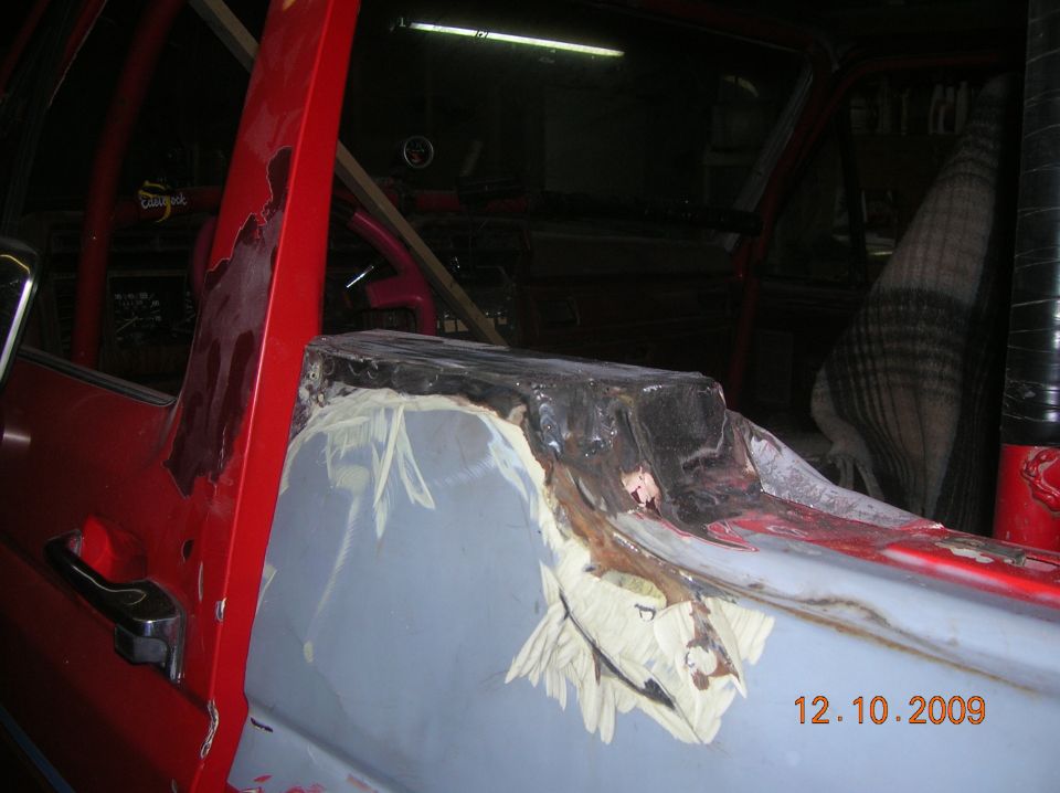 Red vehicle door and interior showing rust repair and bodywork. Date stamp reads 12.10.2009