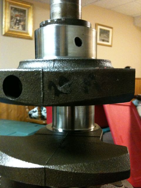 1972 Ford Ranchero - Extreme close-up of a freshly machined engine crankshaft standing on end, showing polished main and rod journals, an oil feed hole, and cas…