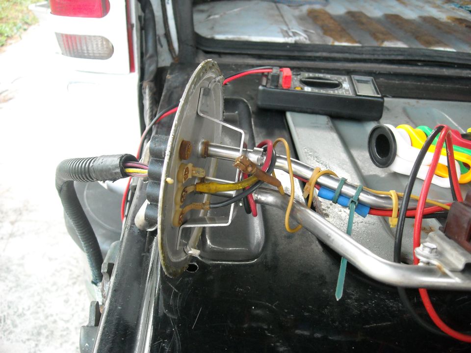 Fuel tank sending unit with wiring and multimeter on rear cargo floor of a Ford Bronco
