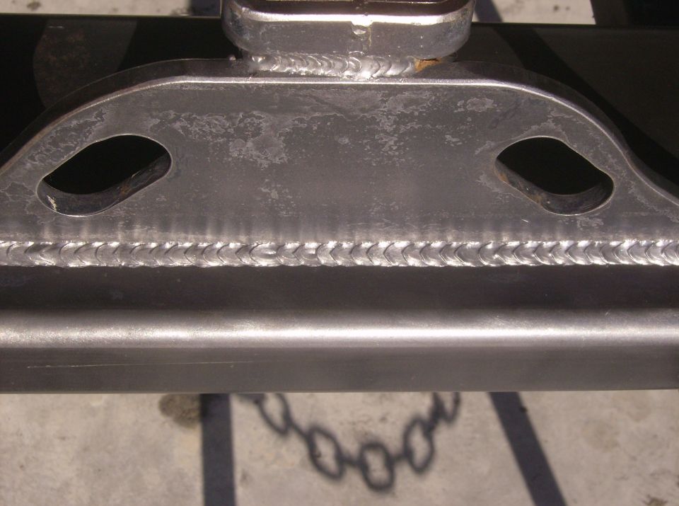 Welded metal frame with two oval cutouts and a shadow of a chain