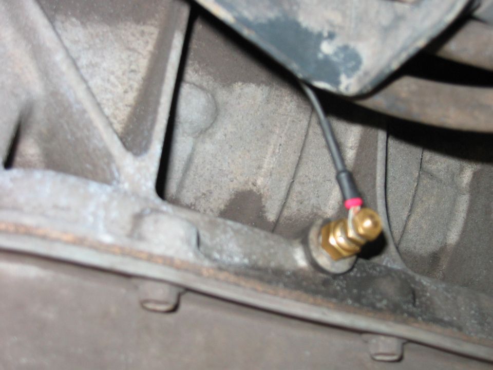 Close-up of a transmission temperature sensor attached to a vehicle's transmission housing