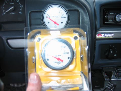1992 Ford Bronco - Dashboard gauges, including an oil gauge and a transmission temperature gauge in its packaging, are visible.
