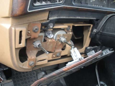 1990 Ford Bronco - The interior of a vehicle shows a disassembled steering column assembly with exposed metal components and wiring.