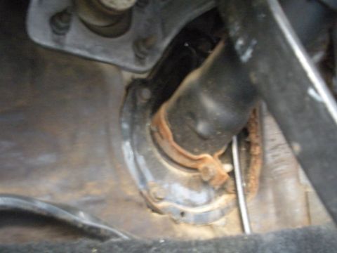 1990 Ford Bronco - The steering column assembly shows signs of rust and wear around its mounting bracket.