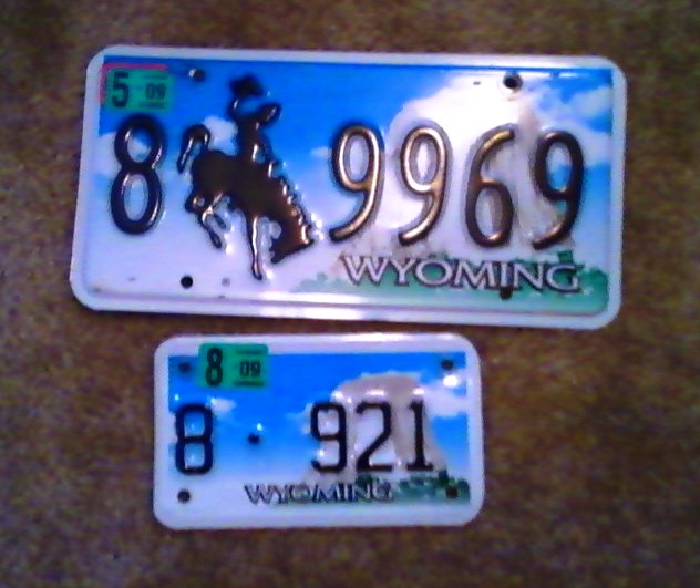 Two Wyoming license plates, one with 8 9969 and a bucking horse, the other with 8 921