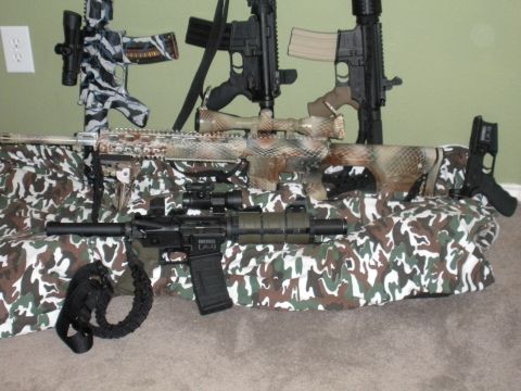 1996 Ford Bronco - Several rifles are displayed with camouflage coverings and scopes, including one with a zebra-like pattern.
