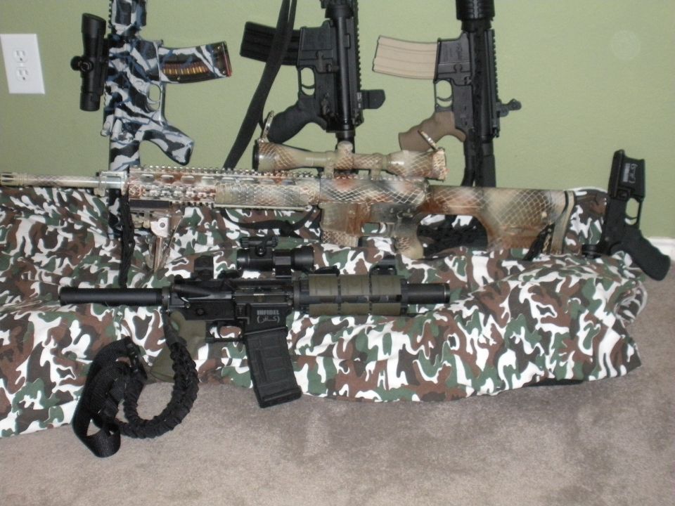 Collection of rifles with camouflage patterns and scopes