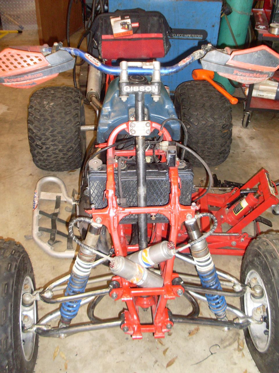ATV front suspension and handlebars with 'GIBSON' visible on stem