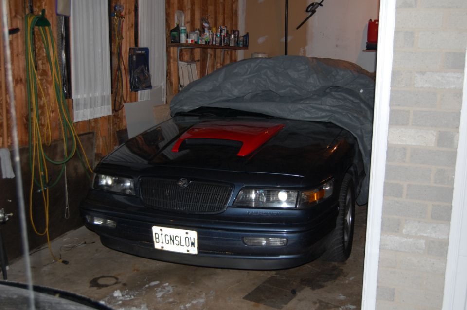 Dark Mercury Cougar in garage with red hood scoop and BIGNSLOW plate