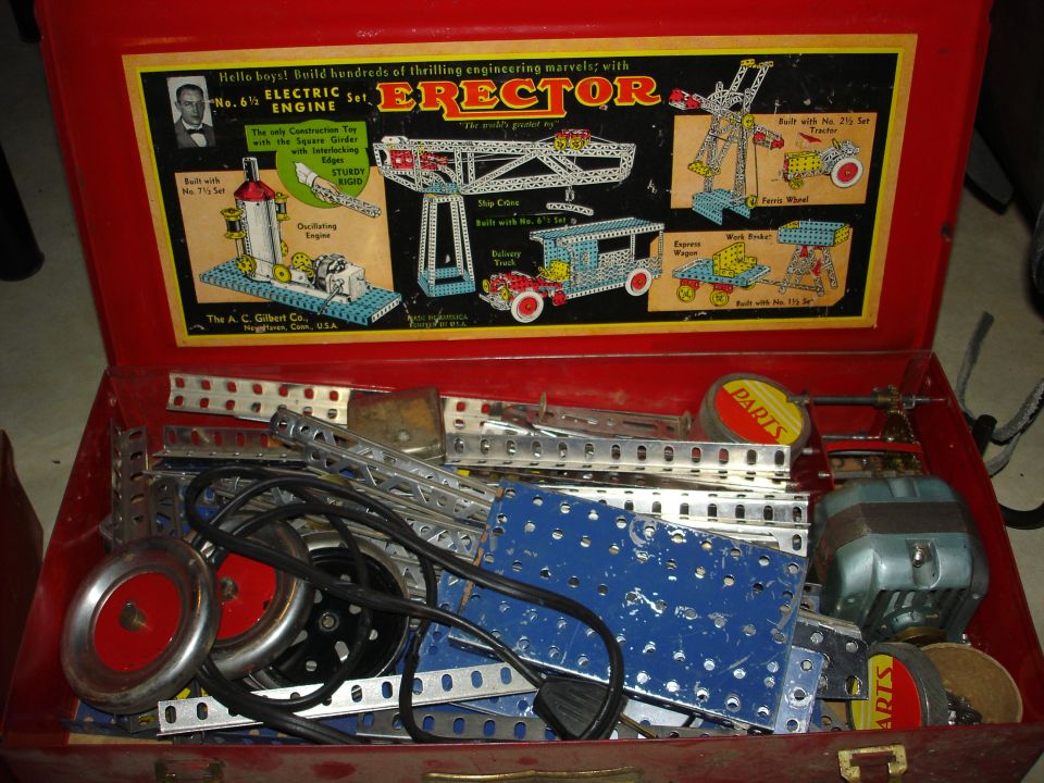 Red Erector Set box with various metal parts and an electric motor