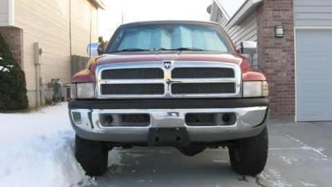 1997 Dodge 2500 - Front view of a red 1997 Dodge 2500 pickup truck parked in a driveway with snow on the ground.