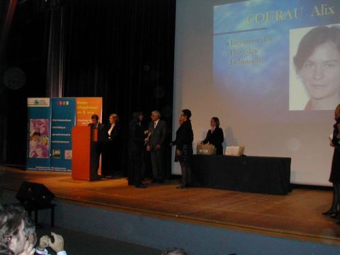 1991 Ford Crown Victoria - An award ceremony is taking place on a stage with several people present and a presentation on a large screen.