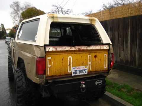 1989 Ford Bronco - This lifted Ford Bronco shows a yellow tailgate with the word "FORD" embossed on it.
