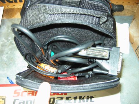 1992 Ford Bronco - A black bag holds various scan tool cables and connectors, including orange and red adapters and a multi-pin connector.
