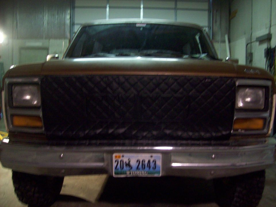 Brown SUV front view with quilted grille cover and Wyoming license plate