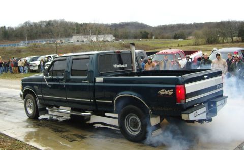 2007 Ford Mustang - A Ford truck emits smoke from its tires while a crowd observes the scene.