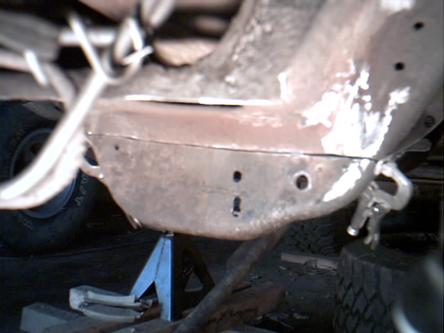 Underside of a truck on a jack stand showing a welded crossmember