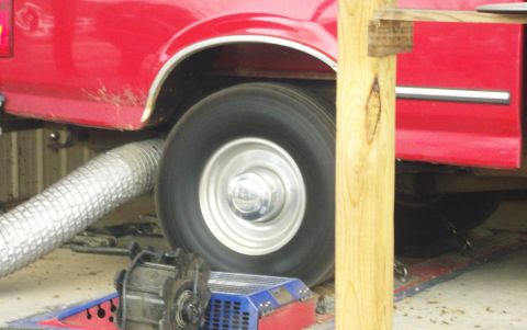 2007 Ford Mustang - A red pickup truck is positioned on a dynamometer for testing, with a flexible exhaust hose connected.