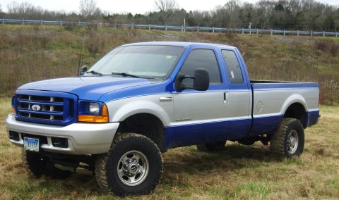 2007 Ford Mustang - This lifted pickup truck features a two-tone blue and silver paint scheme, suggesting it may be a 2007 model year.