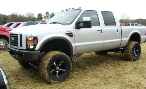 2007 Ford Mustang - Silver Ford F-350 Super Duty pickup truck with large off-road tires and lifted suspension.
