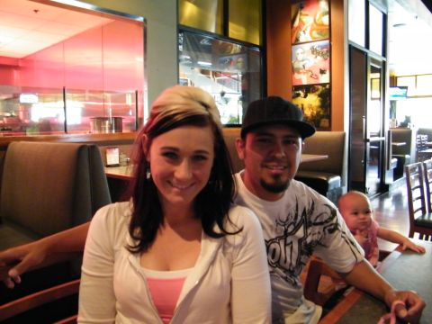 1982 Ford Bronco - A couple poses for a photo with a baby in a restaurant setting.