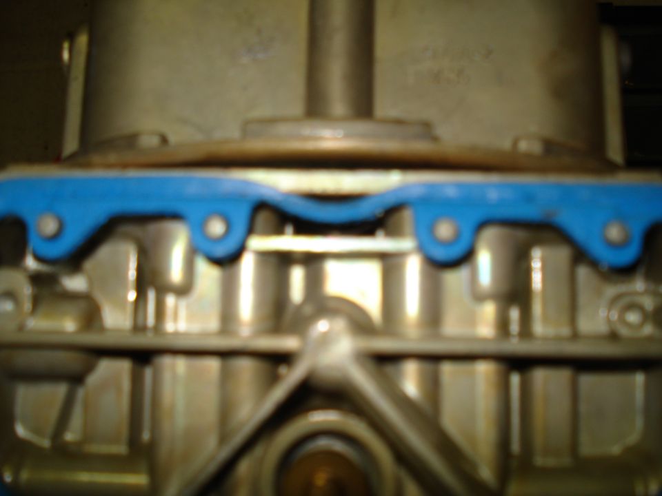 Close-up of a carburetor with a blue gasket