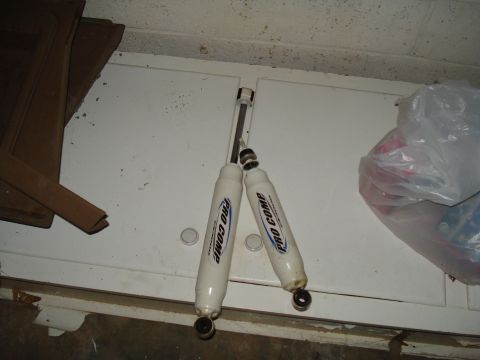 1991 Ford Bronco - Two Pro Comp shock absorbers are shown, likely for sale or storage.