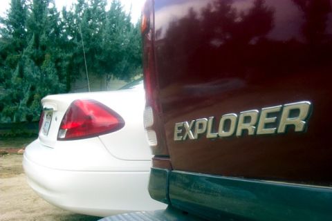 2000 Ford Taurus - Rear view of a red Ford Explorer and a white sedan parked outdoors.