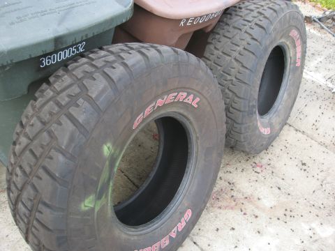 1986 Ford Bronco - Two General Grabber off-road tires are shown, one in the foreground and another behind it.