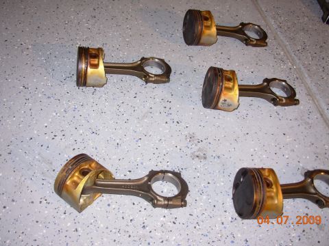 1991 Ford Taurus - Multiple engine pistons with connecting rods are displayed on a garage floor. A date stamp indicates the photo was taken on April 7, 2009.