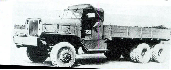 heavy duty truck with wooden bed, six wheels, and canvas-covered cab