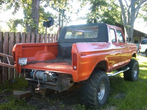 1978 Ford Bronco - Rear view of an orange 1978 Ford Bronco a soft top, lifted suspension, and a winch mounted on the rear bumper.