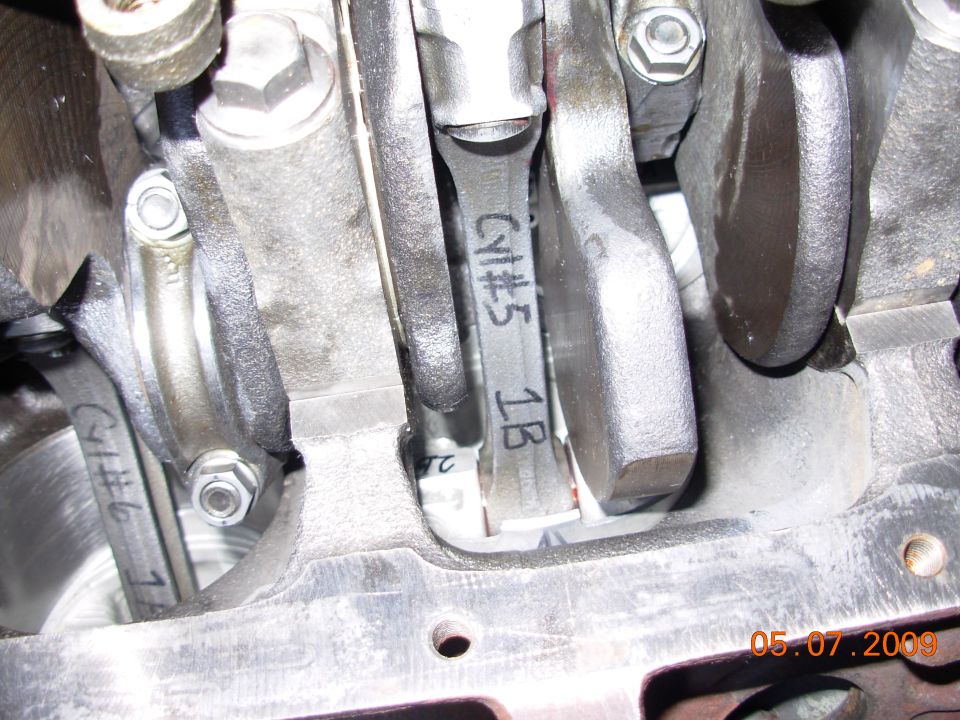 Close-up of engine connecting rods with cylinder numbers marked