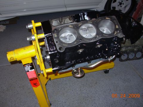 1991 Ford Taurus - Engine block is mounted on a yellow engine stand, ready for assembly or inspection.