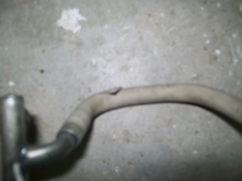 1989 Ford Bronco - Damaged exhaust pipe shown on a concrete surface.