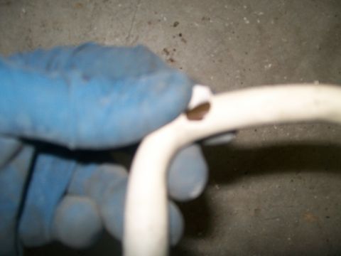 1989 Ford Bronco - A gloved hand holds a damaged white plastic tube against a concrete background, possibly garage floor.