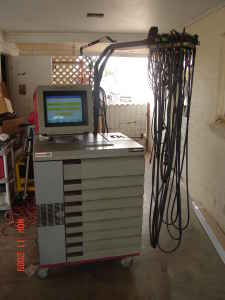 1993 Ford Taurus - A diagnostic machine sits in a garage, with a bundle of cables hanging to the right.