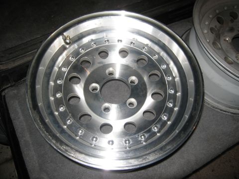 1986 Ford Bronco - A single aluminum wheel is shown, with another wheel visible in the background.