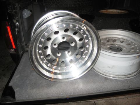 1986 Ford Bronco - Close-up of two alloy wheels, one in sharp focus, positioned within the cargo area of a vehicle.
