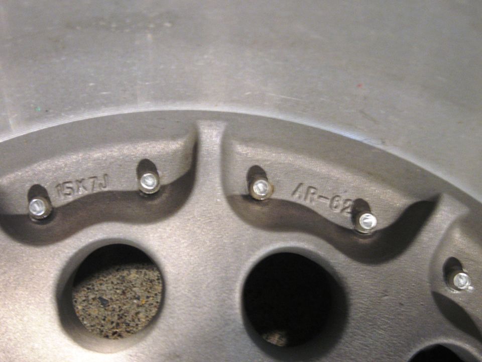Close-up of a wheel with markings '15X7J' and 'AR-62'