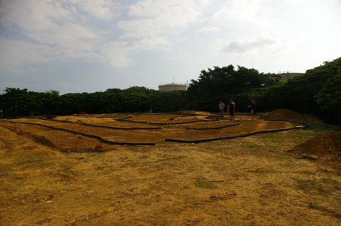 1986 Ford Bronco - An outdoor RC track is under construction with people observing the site.