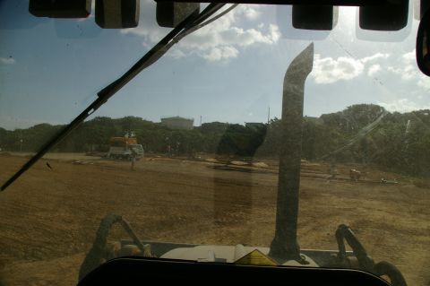 1986 Ford Bronco - Construction site scene with heavy machinery and a truck under a partly cloudy sky.