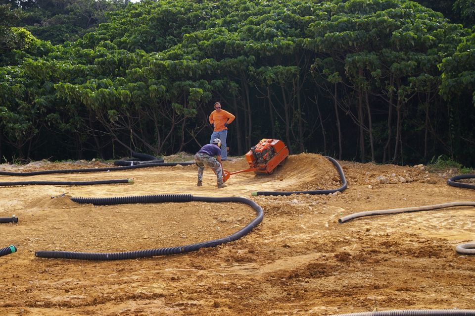 RC track construction scene with two people and a compactor