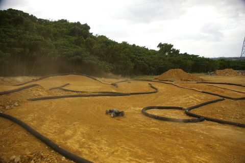 1986 Ford Bronco - A remote control car navigates a custom-built dirt track with various obstacles and turns.