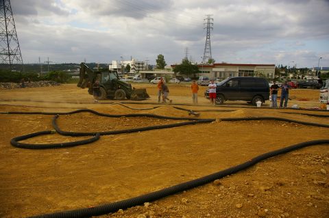 1986 Ford Bronco - People gather around an RC car track with a backhoe and van nearby.