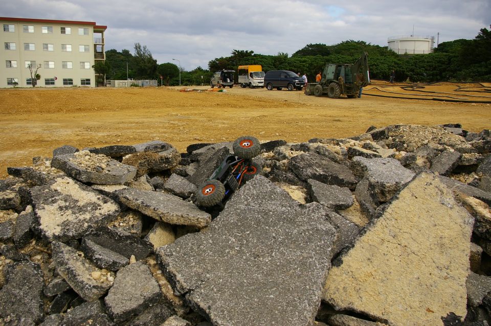 Upside-down remote control rock crawler on asphalt rubble